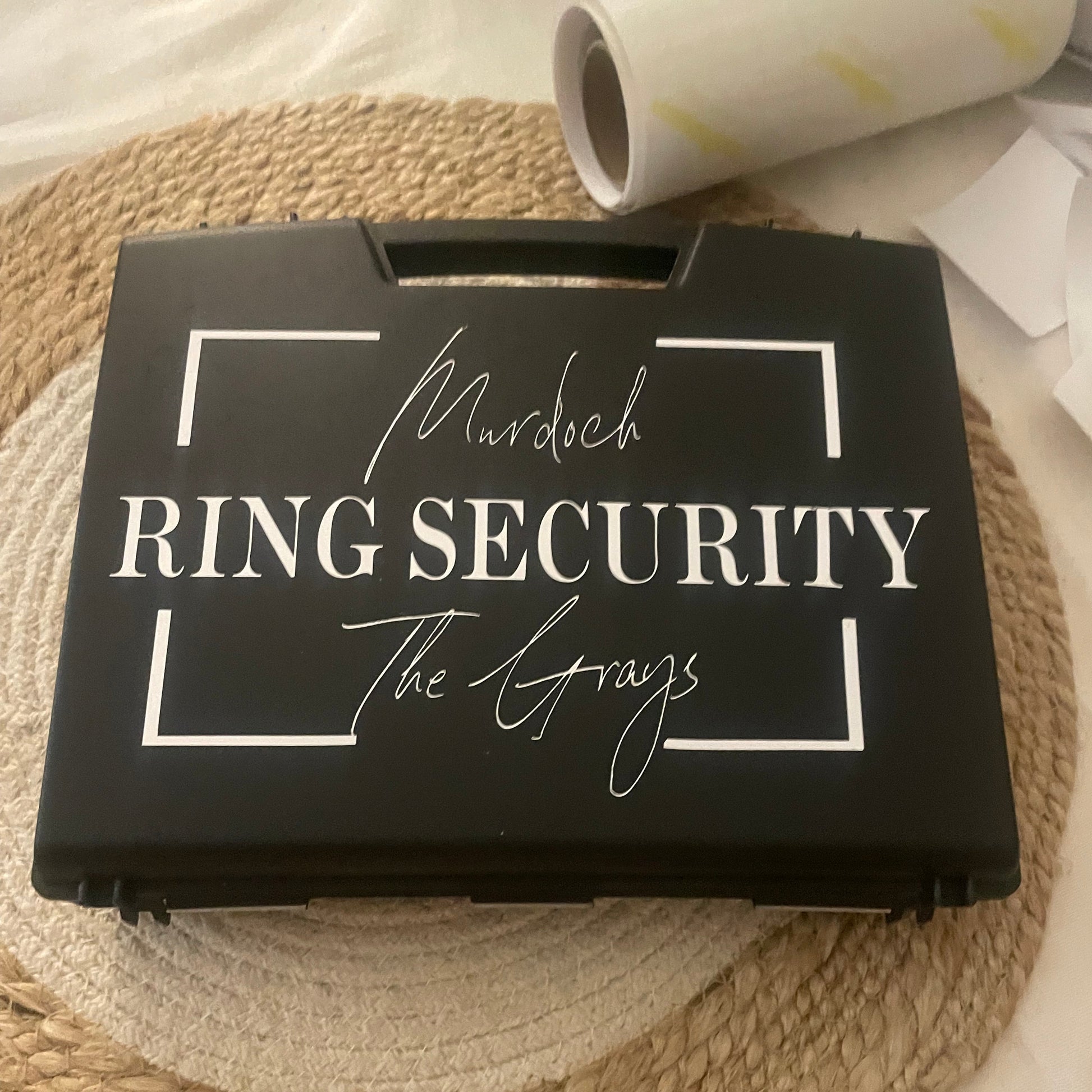 Black box with 'Ring Security' text on a woven mat