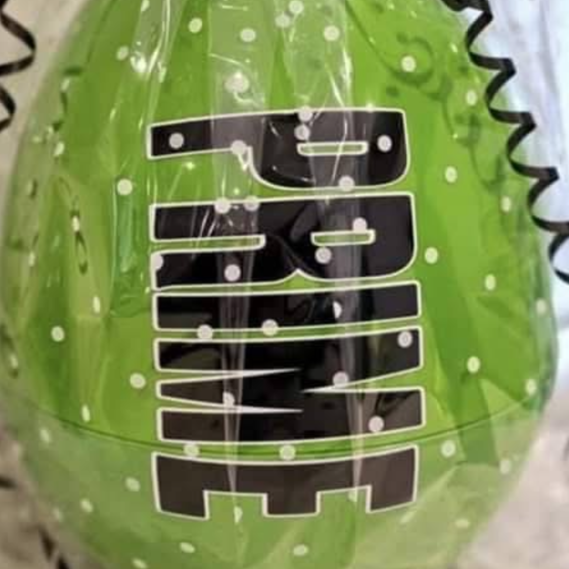 Green ball with black text and a black and green ribbon on a light background