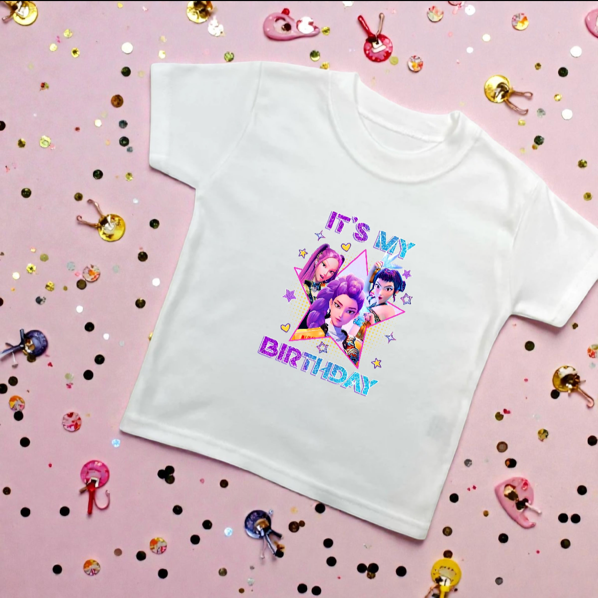 White t-shirt with colorful graphic and text on a pink background with confetti