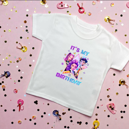 White t-shirt with colorful graphic and text on a pink background with confetti