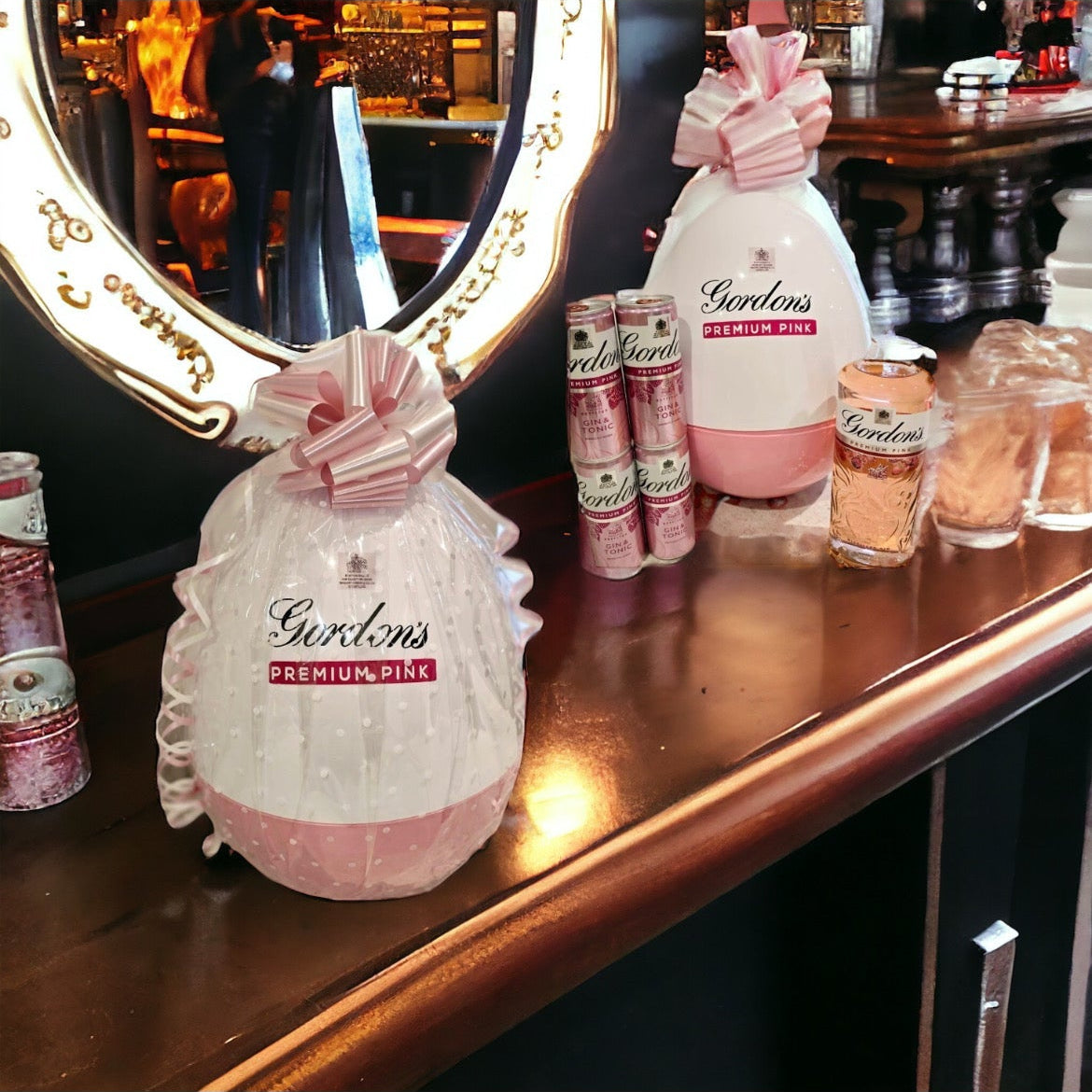 Pink perfume bottles on a wooden surface with a mirror in the background