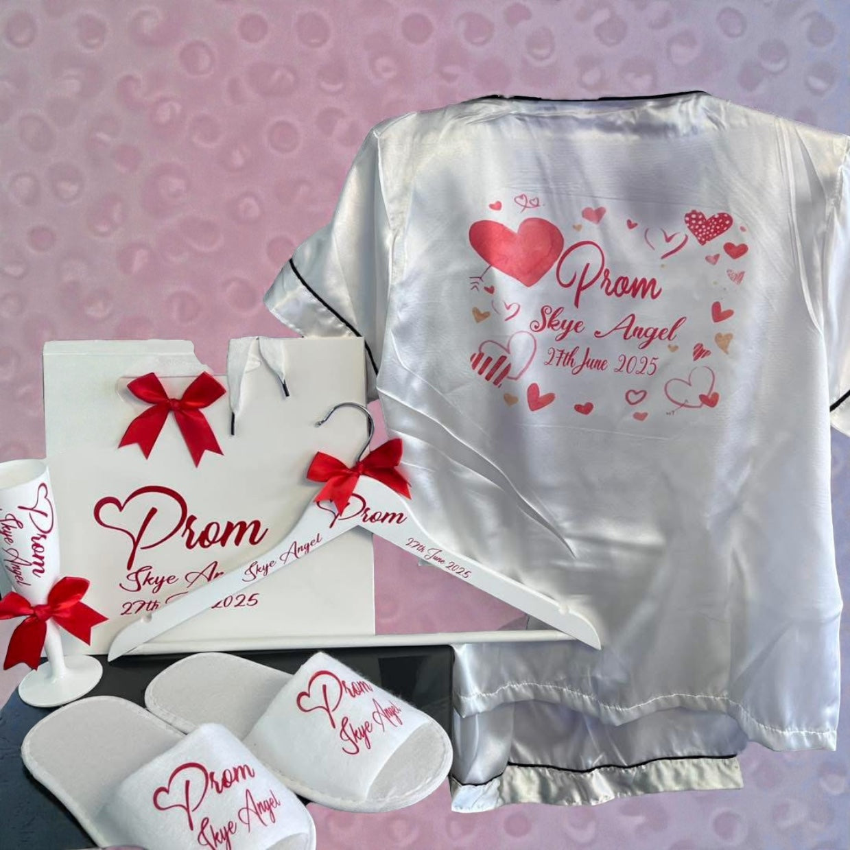 Prom-themed satin robe, hanger, and slippers with personalized text on a pink background.