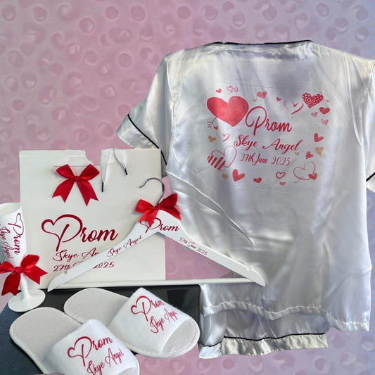 Prom-themed satin robe, hanger, and slippers with personalized text on a pink background.
